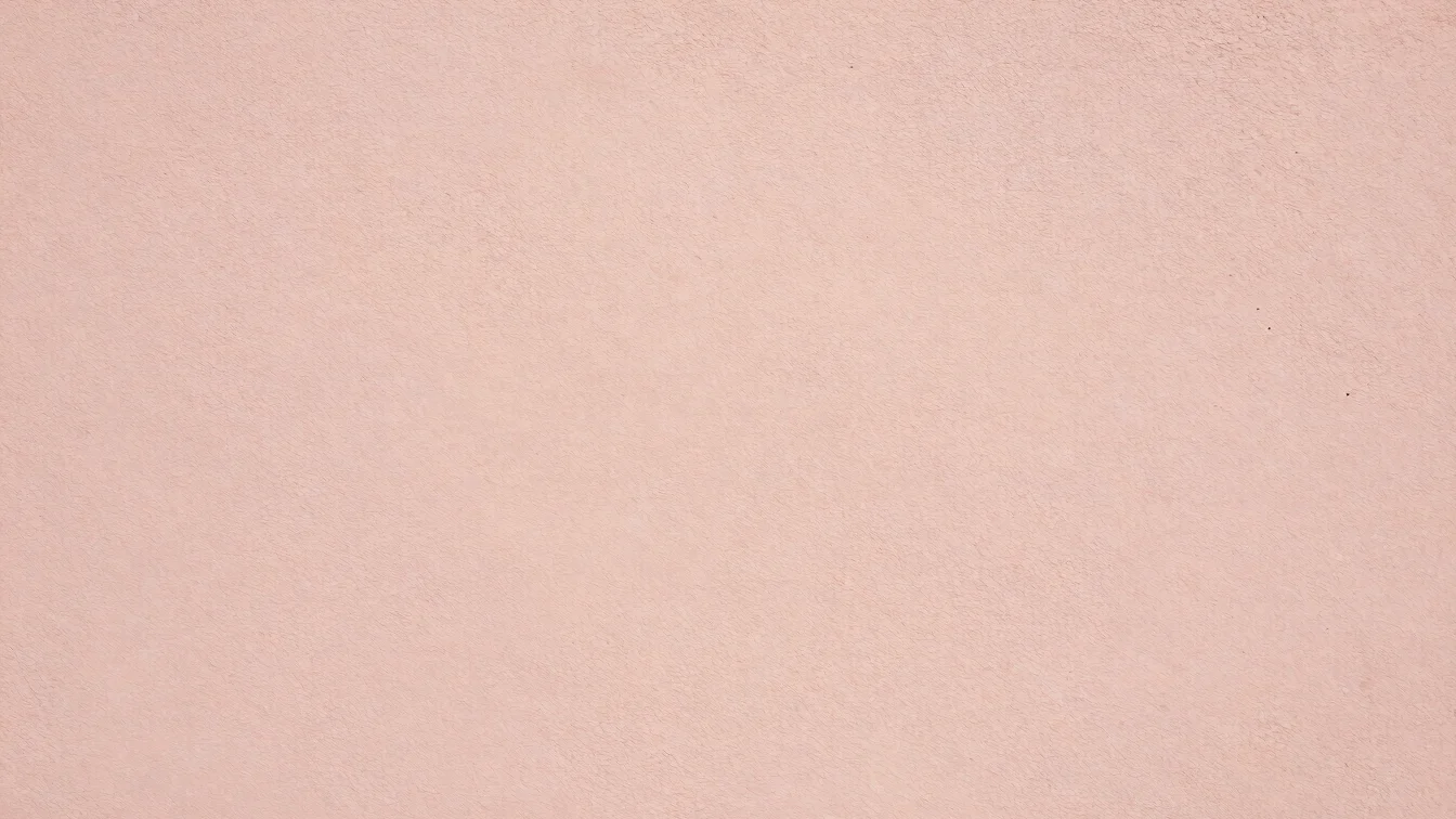Détail d'un mur enduit beige rosé en lumière rasante, gros plan sur la texture, cadrage documentaire, 35mm